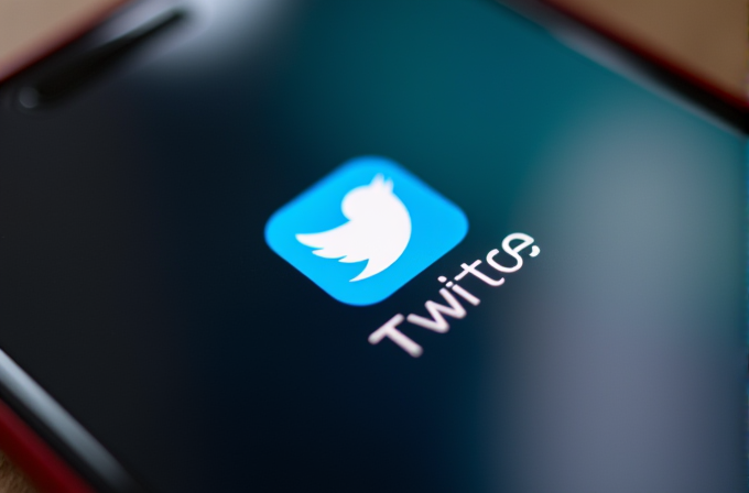 A smartphone screen displays a logo combining elements of Twitter and Twitch.