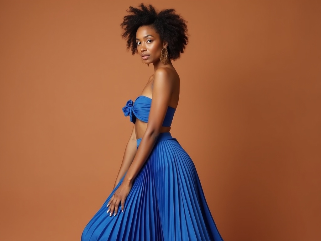 A woman in a flowing blue outfit poses gracefully against a warm brown background.