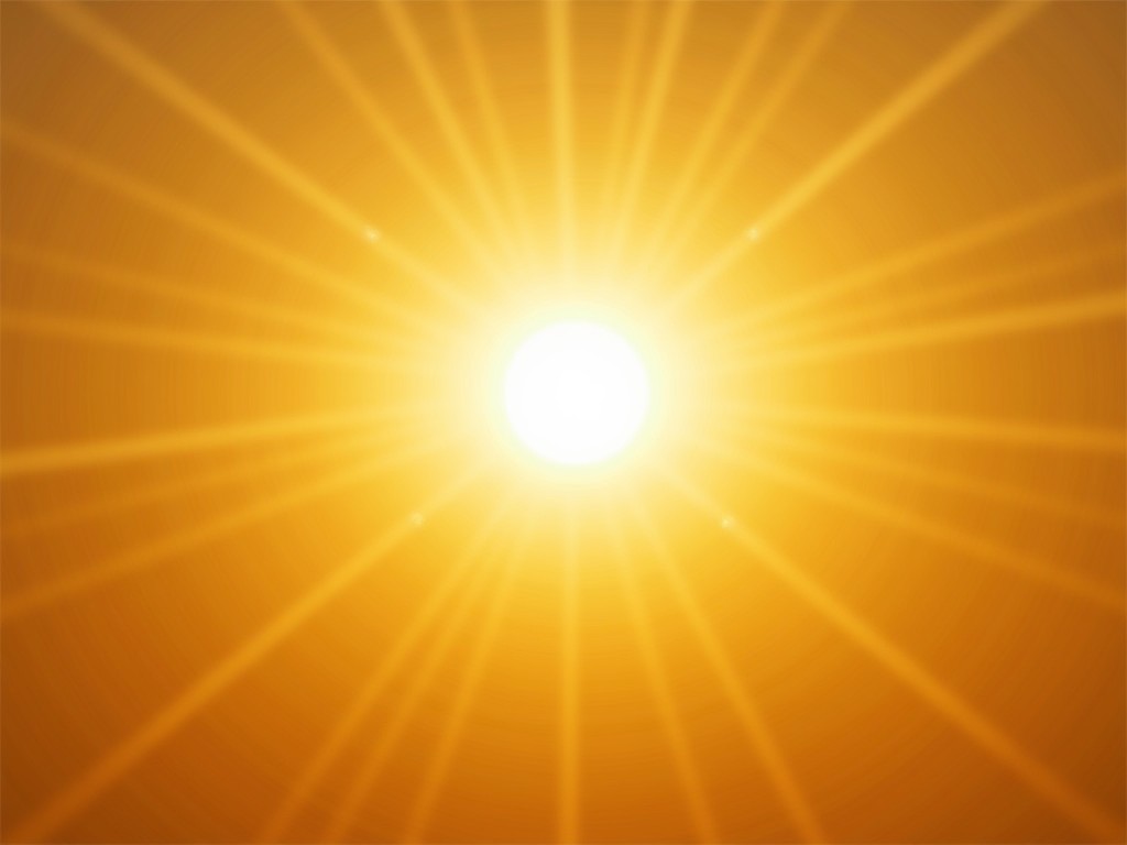 The image displays a radiant sunburst with a vibrant yellow and orange color palette. The center of the image is the brightest point, representing the sun, from which beams of light radiate outward. The symmetrical spread of light rays creates a striking visual effect, symbolizing warmth and energy.