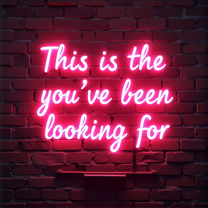 A neon sign on a brick wall reading: 'This is the sign you've been looking for' in bright pink letters.