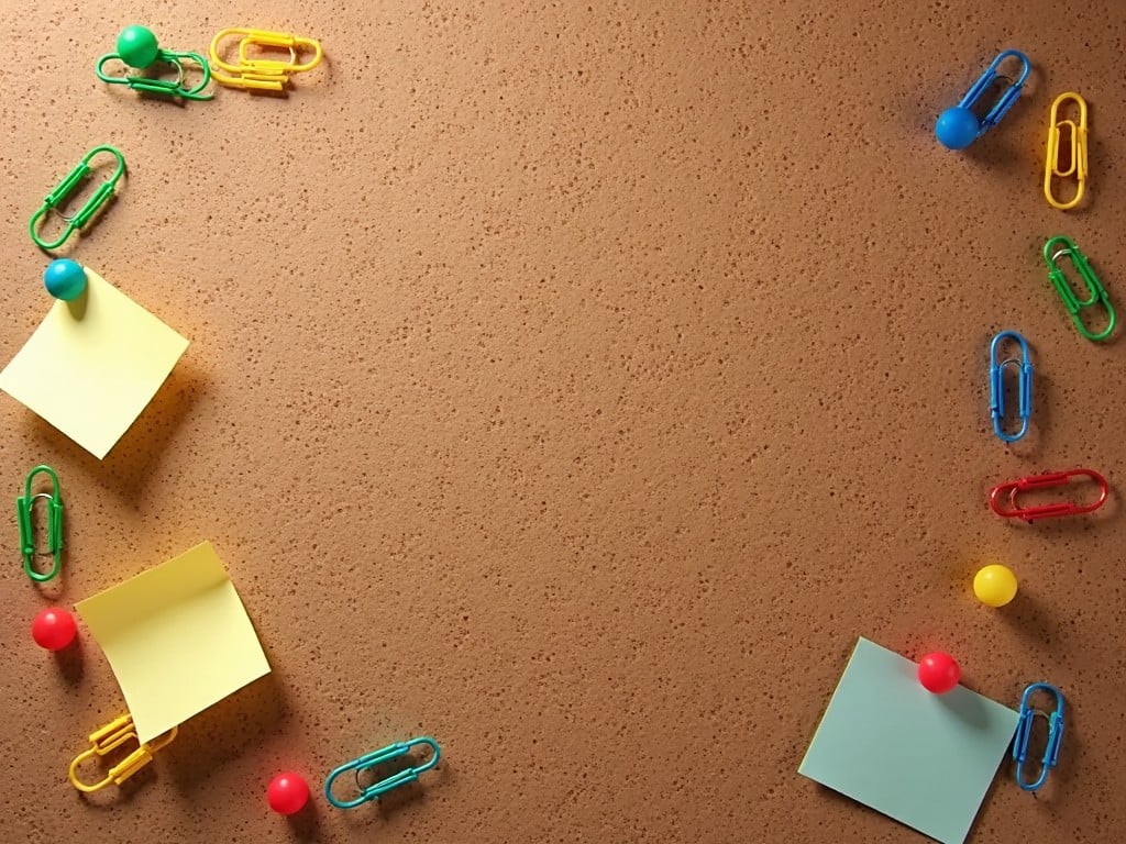 The image features a corkboard background with a playful arrangement of colorful supplies. Yellow and green sticky notes are strategically placed amidst vibrant paperclips in blue, green, and red. There are also red and blue push pins included in the setup. The layout forms a circular pattern around the edges, creating a cheerful and organized workspace vibe. Soft lighting enhances the textures of the corkboard and the bright colors of the stationery items.