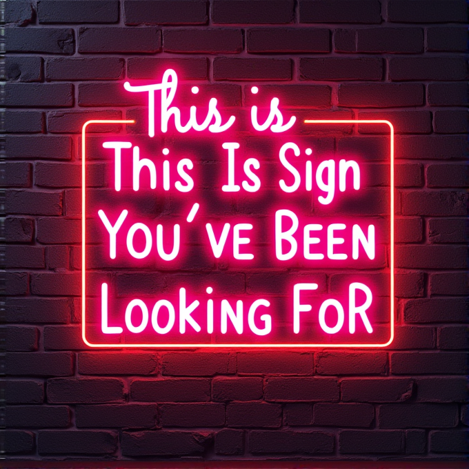 A pink neon sign on a brick wall reads 'This Is The Sign You’ve Been Looking For.'