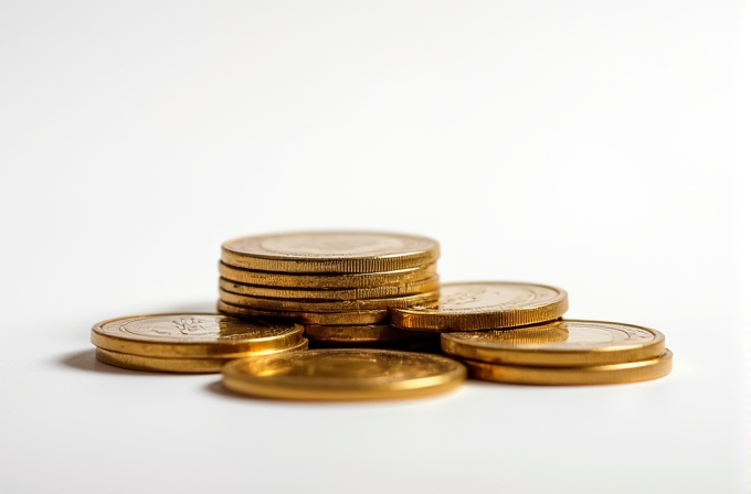 A stack of shiny, gold coins on a white surface, elegantly arranged to create a sense of luxury and wealth.