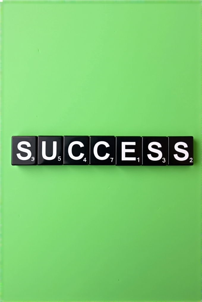 Black letter tiles spelling out 'SUCCESS' are arranged on a bright green background.