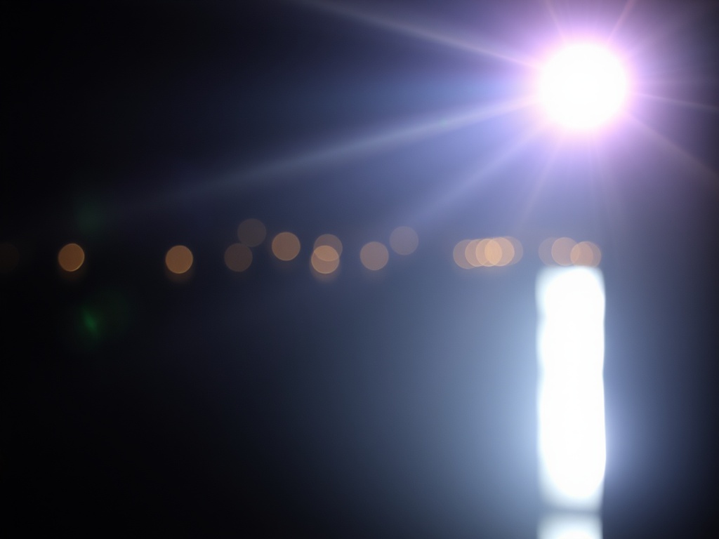 The image captures a bright and radiant light source near the top right, creating a lens flare effect with vivid streaks across a dark background. Below, a series of circular bokeh lights appear in soft focus, suggesting distant city lights reflecting over water. The overall effect gives the image an abstract, ethereal quality.