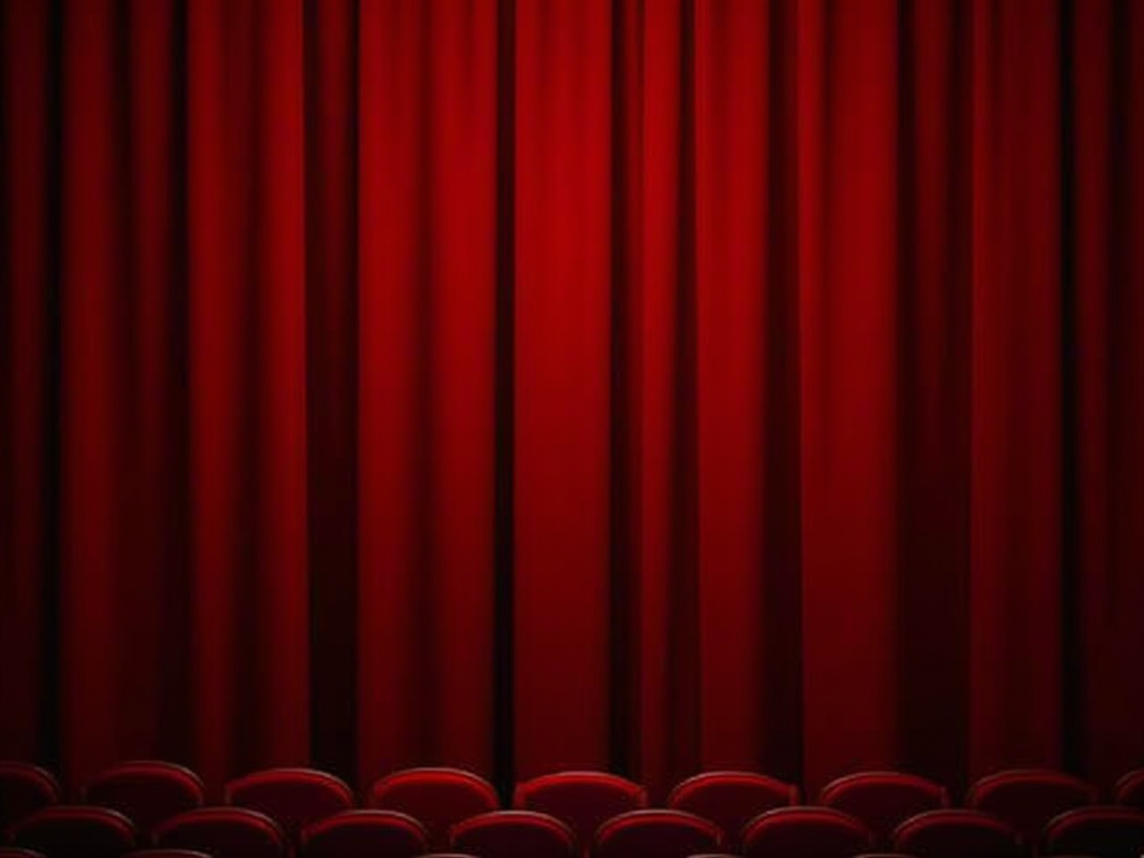 The image shows a red velvet curtain in a theater setting, gracefully draping down in vertical folds. The curtain is rich in color, creating a warm and inviting atmosphere. In front of the curtain, there are rows of empty red seats, indicating that the theater is ready for an upcoming performance. The lighting casts a soft glow on the curtain, enhancing its texture and depth. This scene evokes anticipation and excitement for the show to begin.