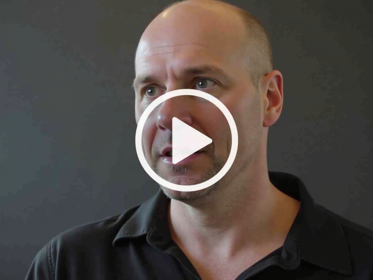 This video cover depicts a man with a confident expression, discussing the first law of power. The background is dark, emphasizing the speaker's face. He is dressed in a casual black shirt, and his direct gaze conveys authority. A play button overlay indicates that this is a video. The focus is on engaging the audience with insights about power dynamics. This visual is aimed at attracting viewers interested in self-improvement and leadership strategies.