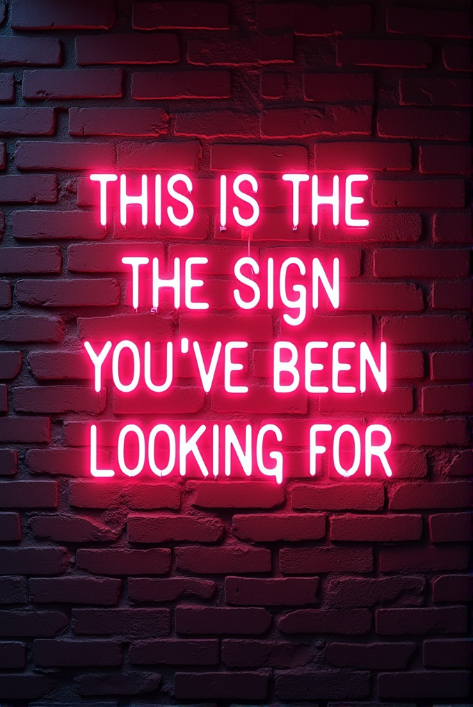 A neon sign displaying the motivational phrase 'THIS IS THE SIGN YOU'VE BEEN LOOKING FOR' against a dark brick wall.