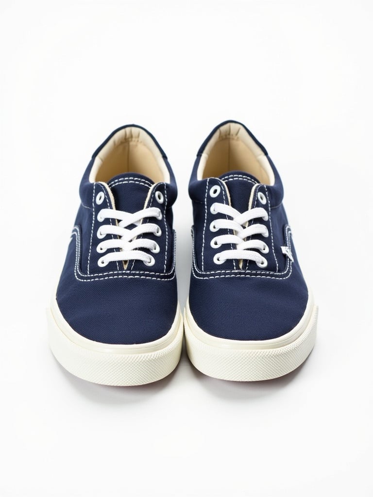 Stylish pair of sneakers. Navy blue canvas upper. White rubber sole with texture. White laces and stitching. Interior lined with beige. Casual and versatile design.