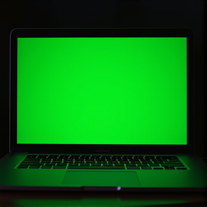 A laptop screen brightly displays a solid, vivid green color in a dark setting.