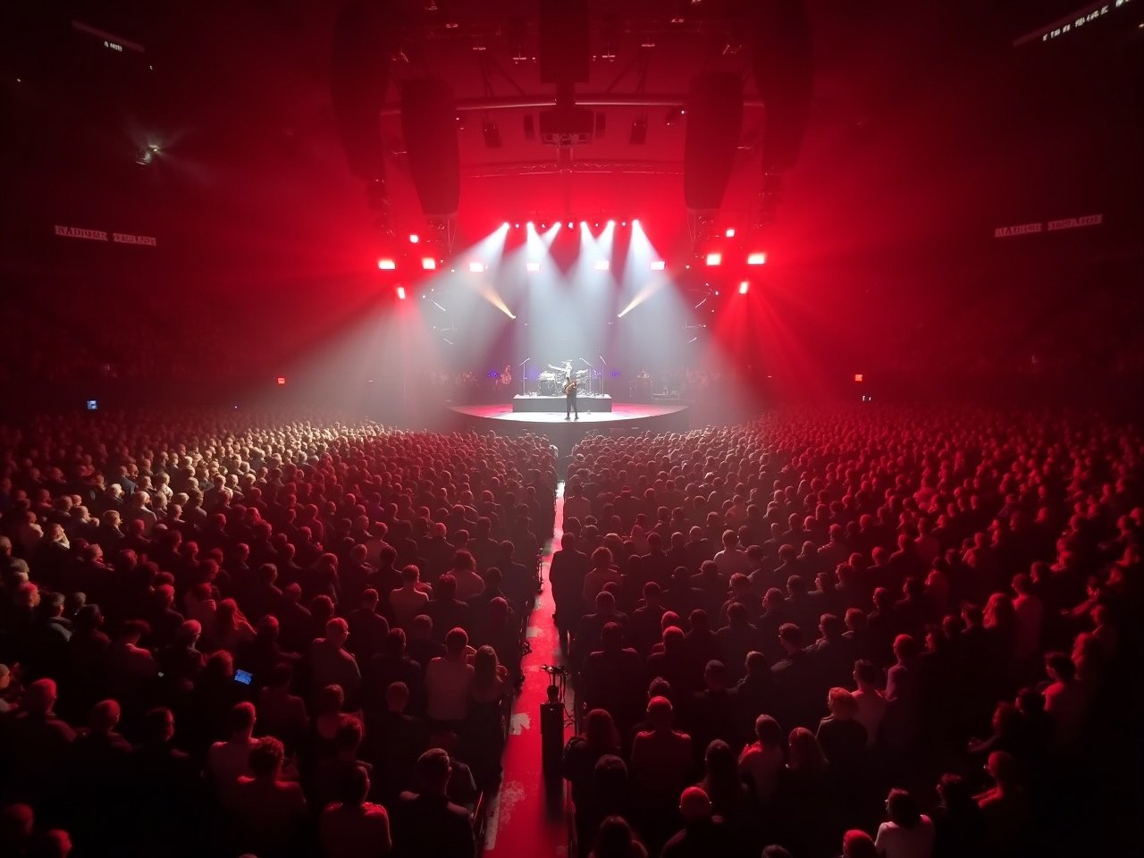 This image captures a dynamic concert scene featuring a performance at Madison Square Garden. The Metal Thunder band is showcased on stage, illuminated by dramatic lighting that creates an electrifying atmosphere. A massive audience surrounds the stage, reflecting the energy and excitement of the event. The perspective is unique, resembling a bird's eye view, which offers a remarkable look at the crowd and the stage. The color palette predominantly features intense reds and soft whites, enhancing the overall experience of the concert.