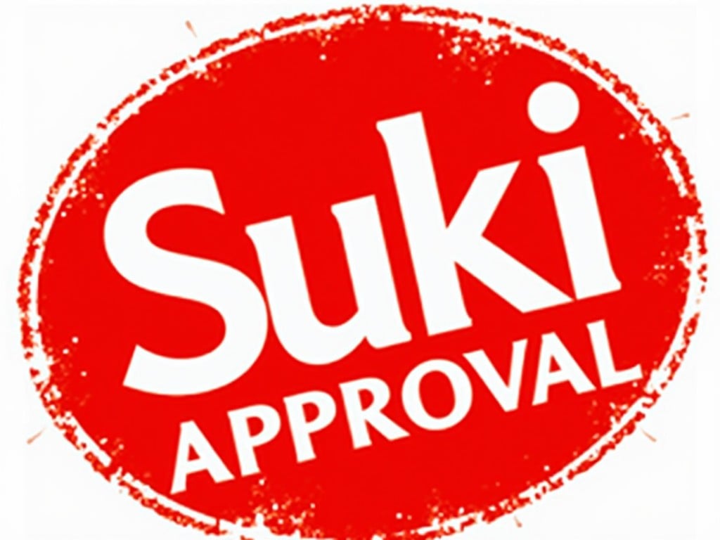 This image depicts a stamp of approval with the words 'Suki Approval' prominently featured. The design is bold and uses a vibrant red background that captures attention. The text is large and easy to read, making the approval obvious to anyone viewing it. This kind of stamp is often used in marketing to denote quality or endorsement. It could be used on products, promotional materials, or in digital marketing efforts to express consumer confidence.