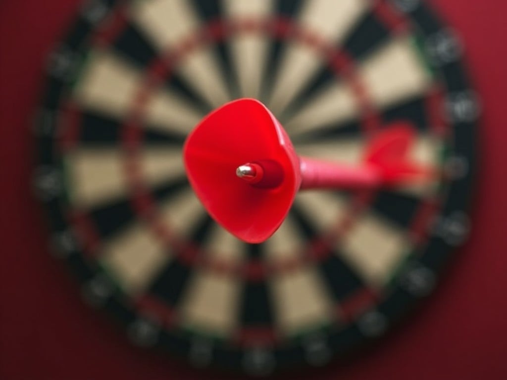 The image features a vibrant red dart prominently placed in sharp focus, emerging sharply against a blurred dartboard backdrop. The dart symbolizes precision and accuracy in sports. The dartboard, mostly out of focus, highlights the context of gameplay. The background colors blend in a way that emphasizes the dart's striking red hue. The composition invites viewers to consider the skill involved in achieving a perfect throw.